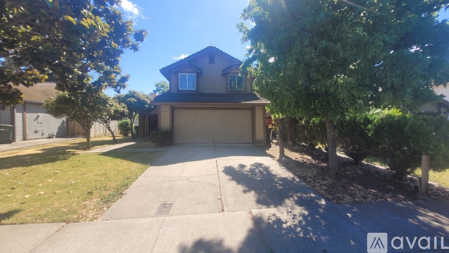 A house with a driveway and trees in front.