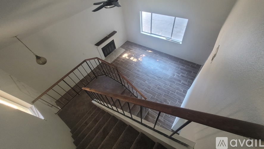A staircase with a metal railing leads up to a window.