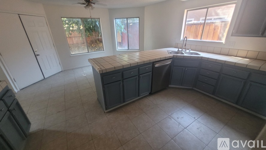 A kitchen with a countertop, sink, and cabinets is available for rent.