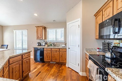 A kitchen with wooden cabinets and a black stove top.
