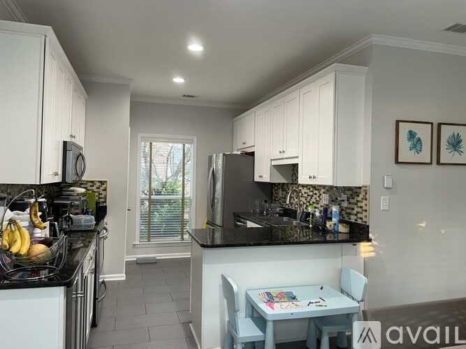 A kitchen with black countertops and white cabinets.