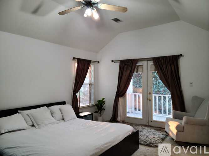 A bedroom with a large bed and a ceiling fan.