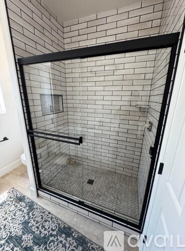 A bathroom with a black frame around the shower.