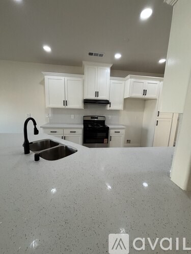A kitchen with white cabinets and a granite countertop.
