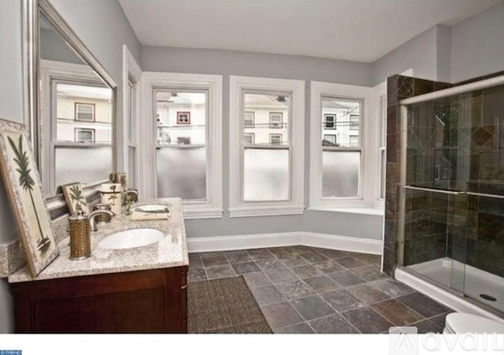 A bathroom with a sink, mirror, and tiled floor.