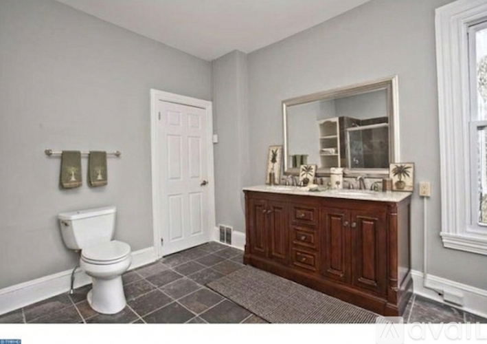 A bathroom with a toilet, a sink, and a mirror.