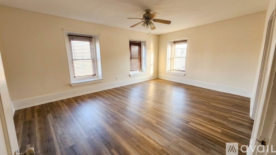 A room with wooden flooring and a ceiling fan.