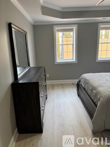 A bedroom with a bed, dresser, and mirror.
