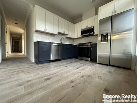 A kitchen with white cabinets and stainless steel appliances.