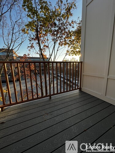 A deck with a railing and trees in the background.