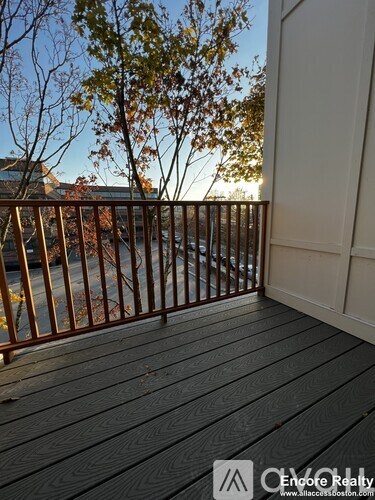 A deck with a railing and trees in the background.