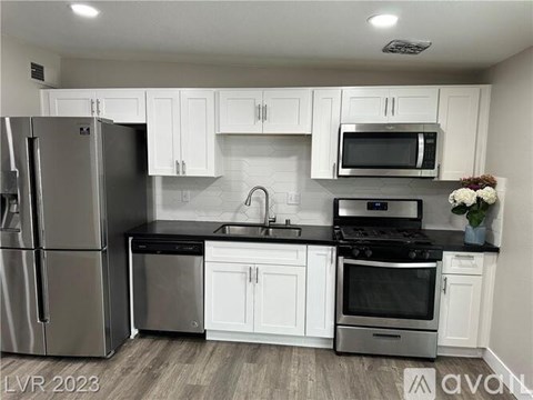A kitchen with white cabinets and stainless steel appliances.