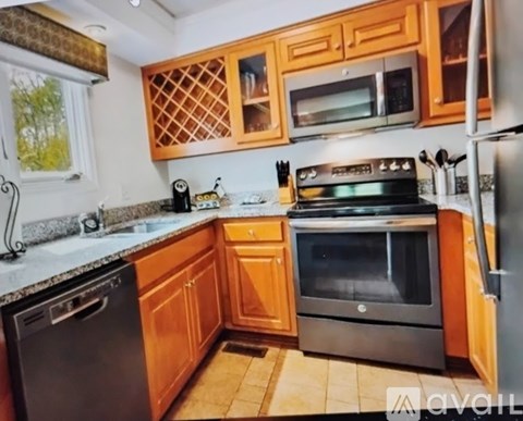A kitchen with wooden cabinets and a black stove top oven.