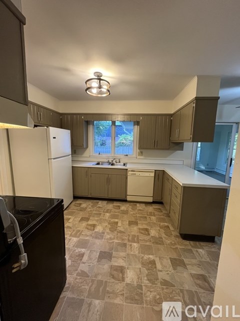 A kitchen with brown cabinets and a black counter top.