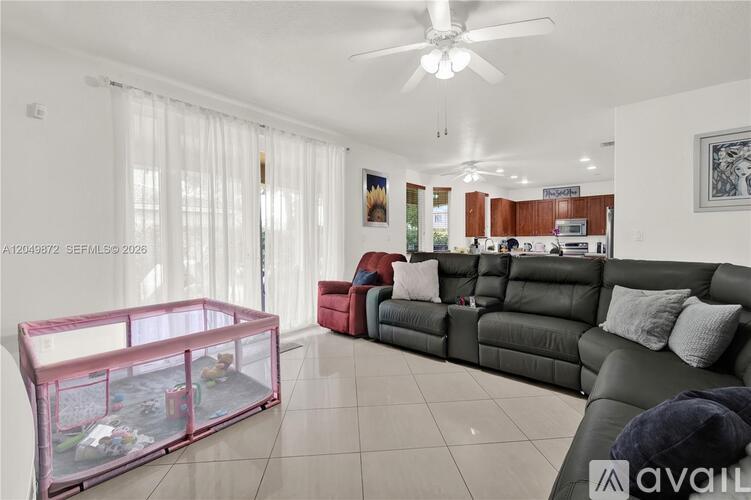 A living room with a grey couch and a pink fish tank.