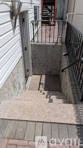 A stairway with a metal railing and a concrete landing.