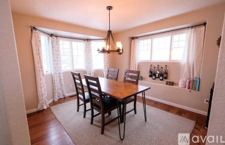 A dining room with a wooden table and chairs.