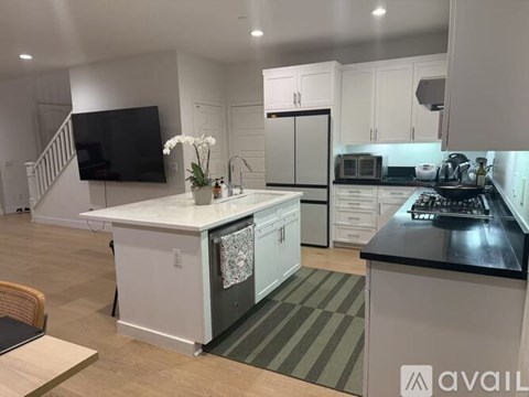 A modern kitchen with white cabinets and a black countertop.
