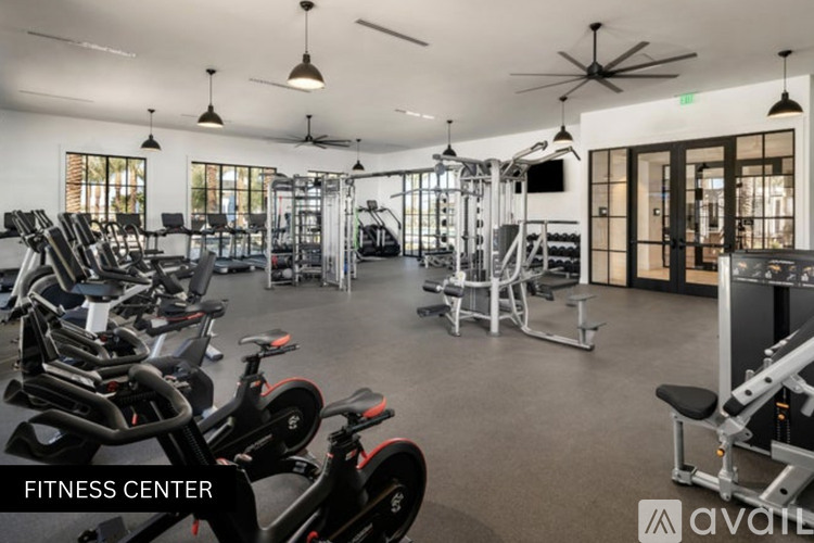 A fitness center with a variety of equipment including treadmills, weights, and exercise bikes.
