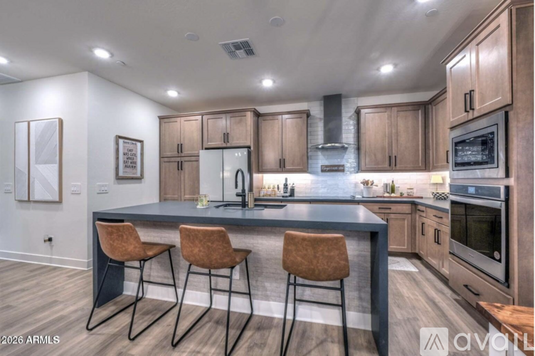 A modern kitchen with wooden cabinets and a dark countertop.