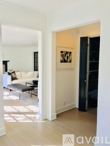 A living room with a black bench and a painting on the wall.