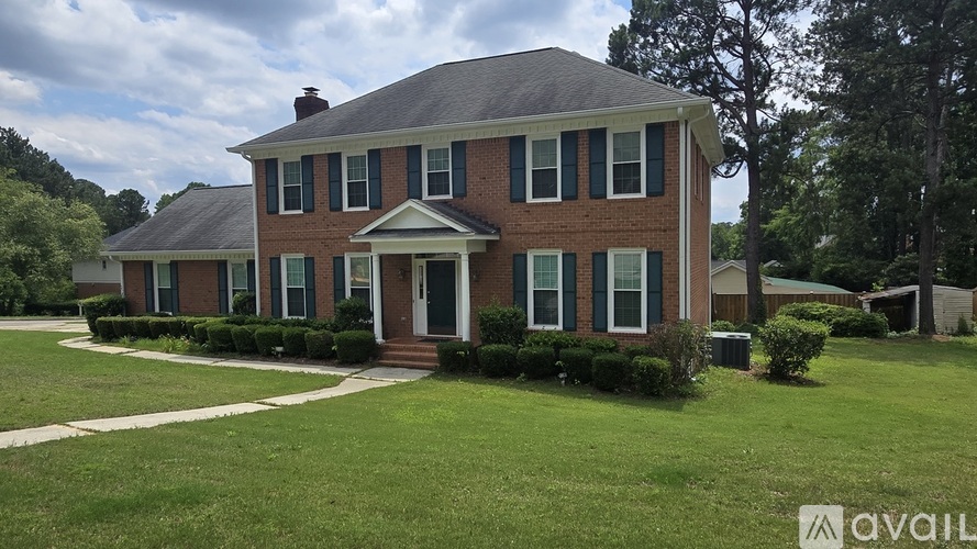 A brick house with a white door and windows.