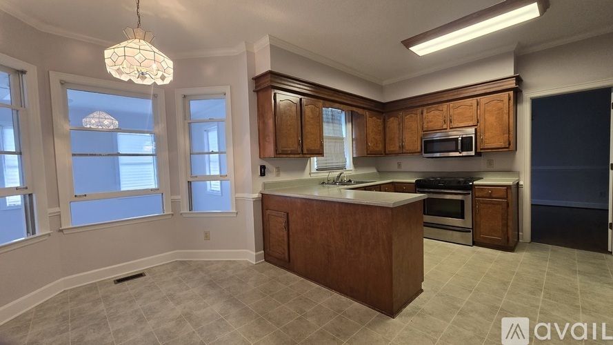 A kitchen with wooden cabinets and a large island.