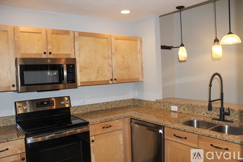 A kitchen with wooden cabinets and a black stove top oven.