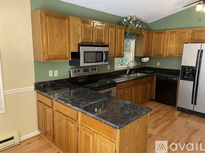 A kitchen with wooden cabinets and granite countertops.