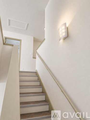 A staircase with a light switch on the wall.