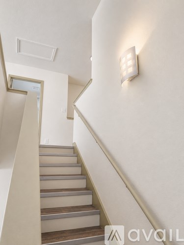 A staircase with a light switch on the wall.