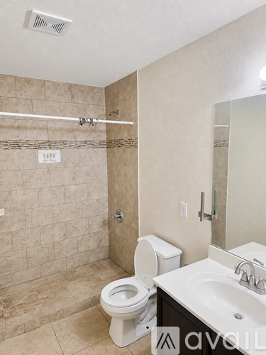 A bathroom with a toilet, sink, and tiled shower.
