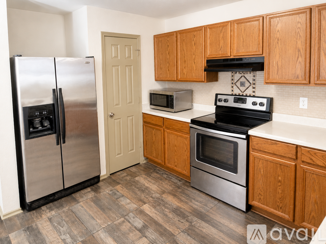 A kitchen with a refrigerator, oven, microwave, and cabinets.