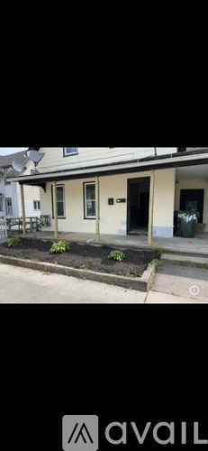 A house with a front yard and a black door.