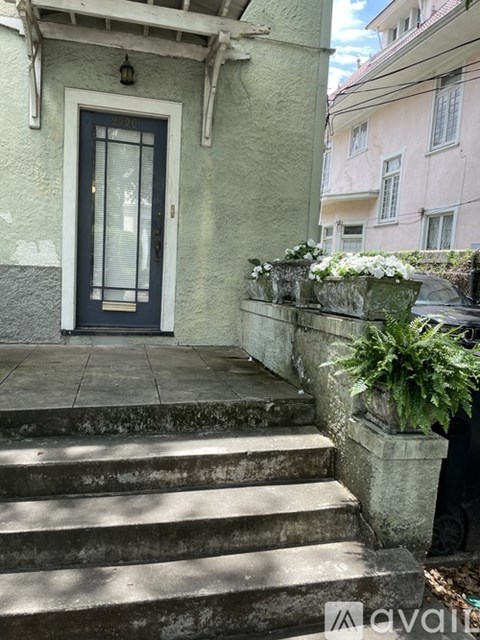 A house with a dark door and steps leading up to it.