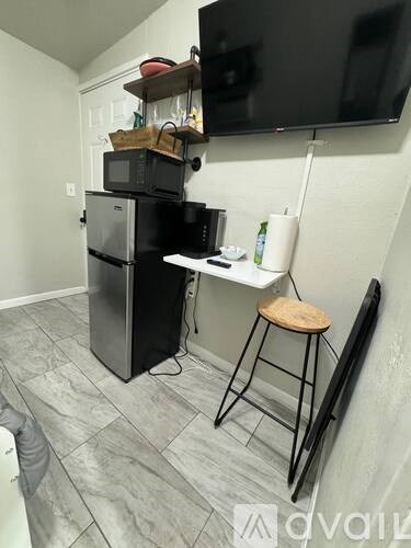 A black microwave and oven are on a countertop in a kitchen.
