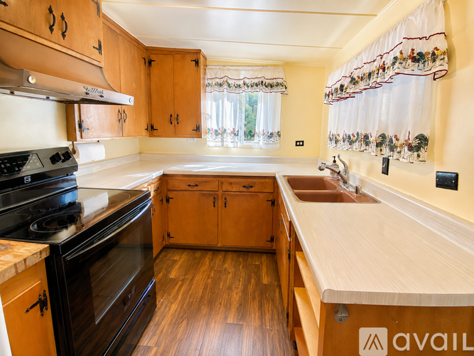 A kitchen with wooden cabinets and a black stove top oven.
