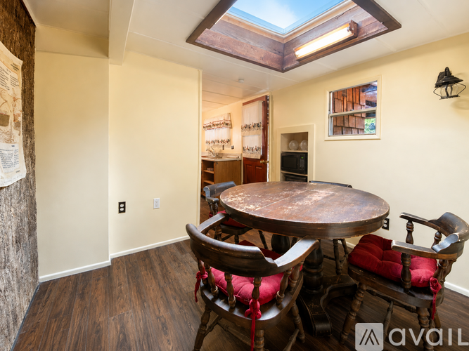 A dining room with a round wooden table and chairs.