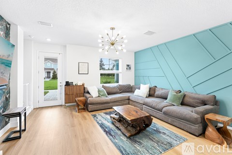 A living room with a grey couch and a wooden coffee table.