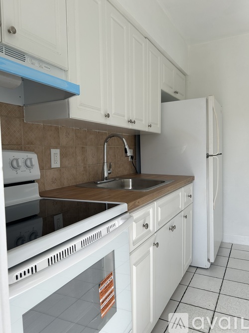 A kitchen with white cabinets and a white oven.