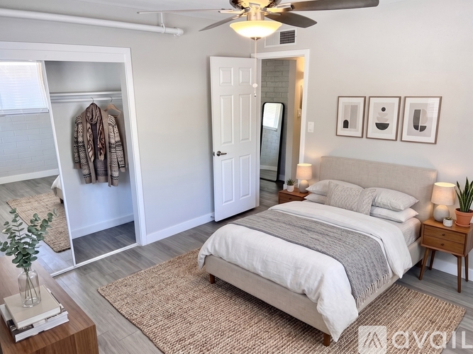A bedroom with a bed, a ceiling fan, and a wardrobe.