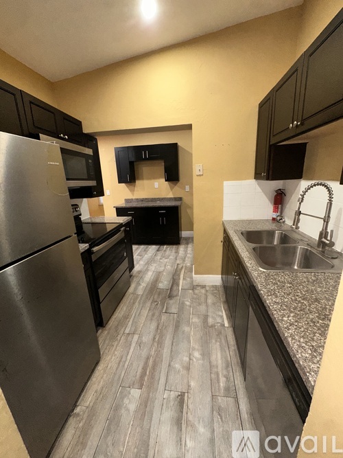 A kitchen with a stainless steel refrigerator and a sink.