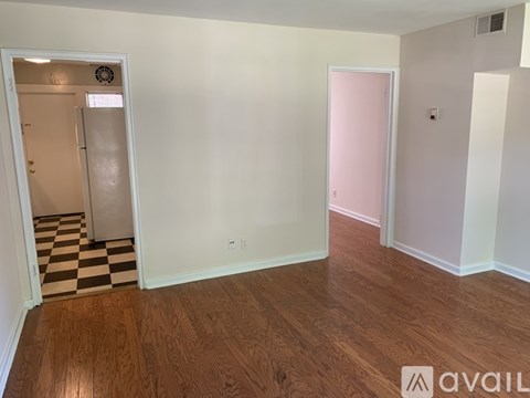 A room with a checkered floor and a white door.