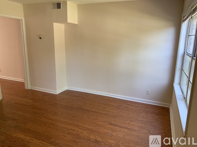 A room with wooden flooring and white walls.