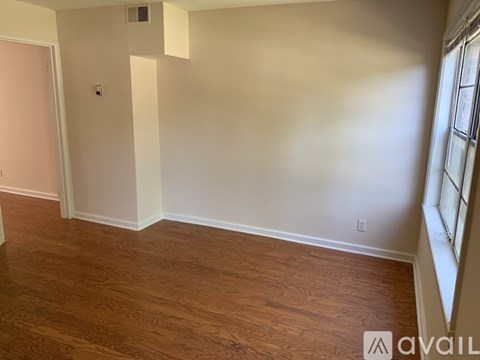 A room with wooden flooring and white walls.