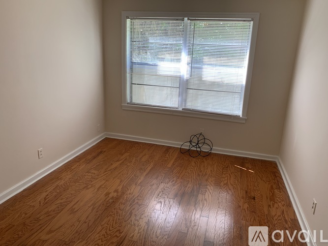 A room with a window and wooden flooring.