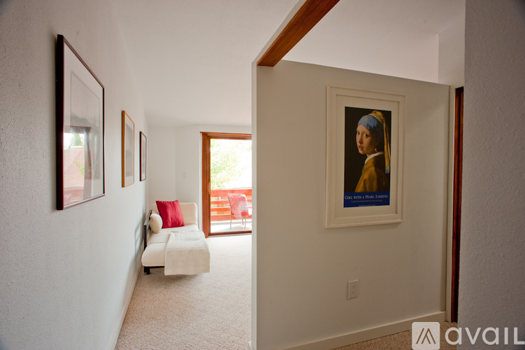 A living room with a couch and a painting on the wall.