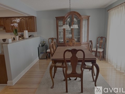 A dining room with a wooden table and chairs.