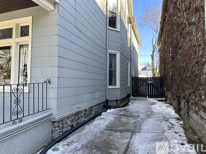 A narrow alley with a metal fence and a building on the left.