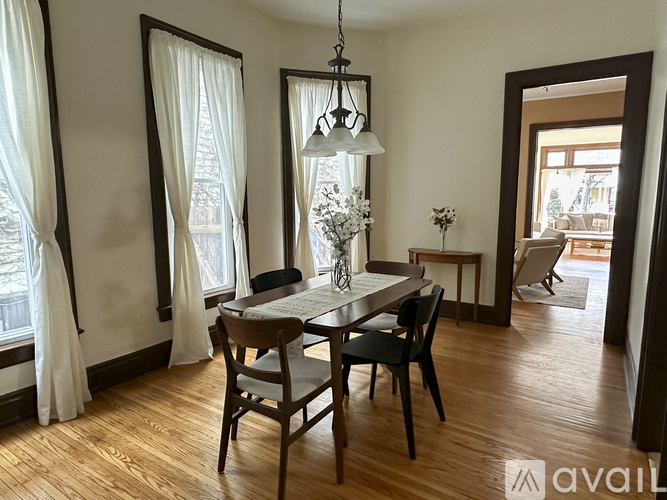 A dining room with a wooden table and chairs.